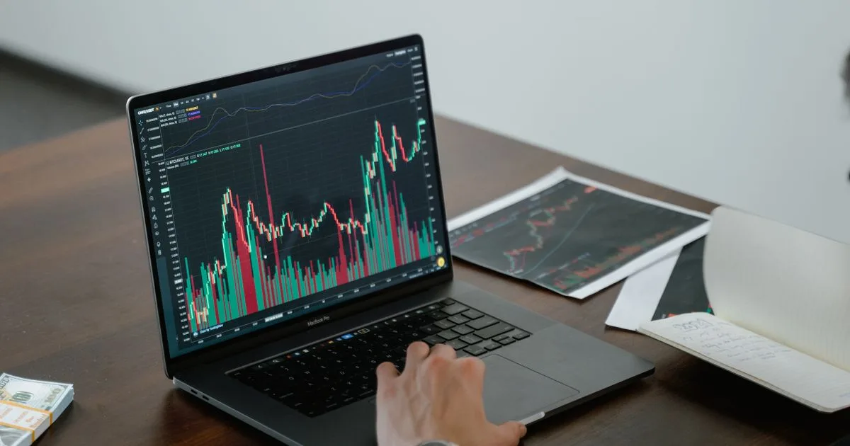 A person analyzing data on a laptop screen with charts and graphs visible