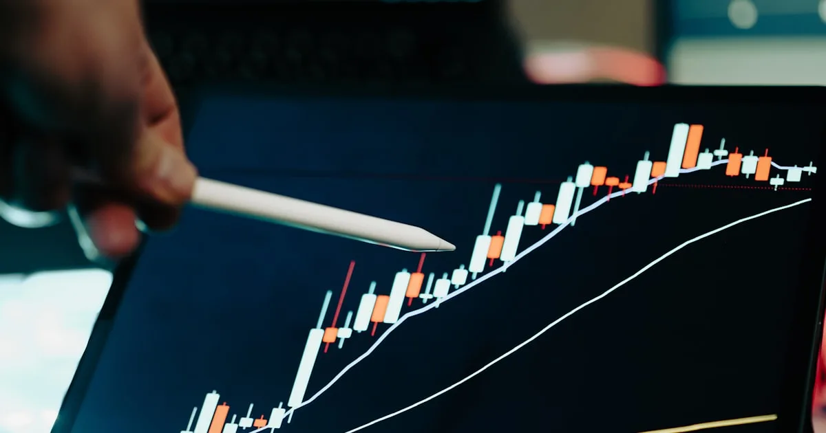 A person points to a performance chart on a laptop screen while reviewing KPI data